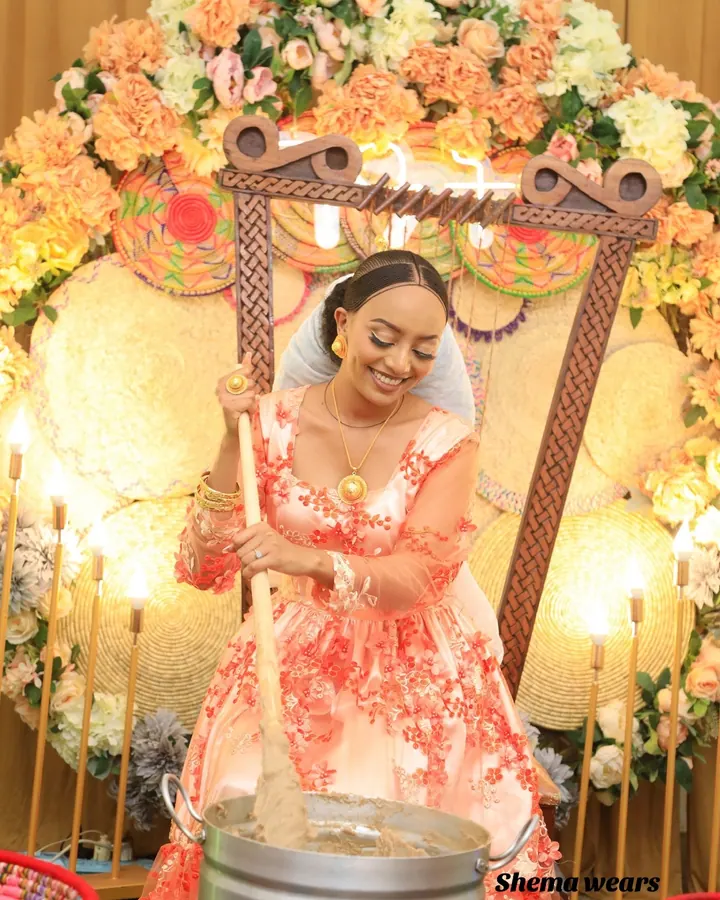 Woman at a Ge’at celebration in a long coral and white floral dress with sheer sleeves and a veil