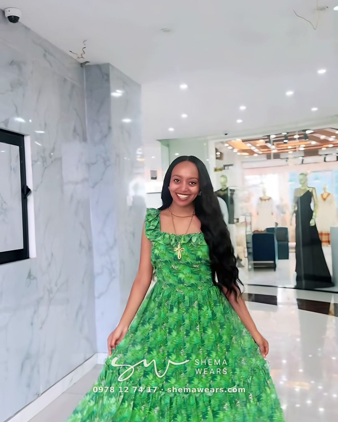 Model in a long green printed chiffon dress with a tiered skirt