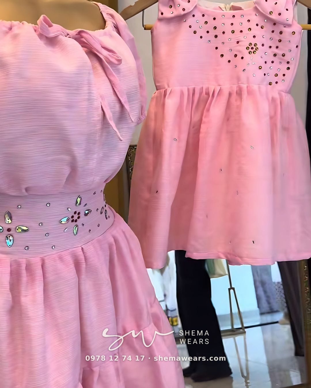 Matching pink dresses for mother and daughter — an off-shoulder dress with a jewelled belt and a little dress with bows