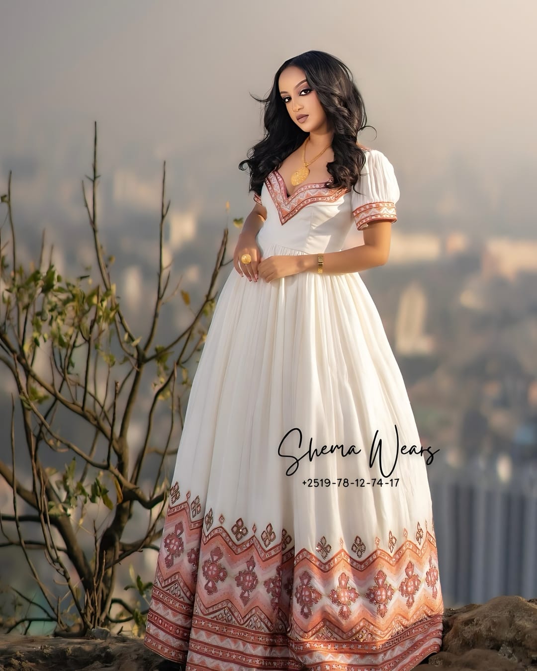 Bride in a white habesha kemis with puff sleeves, rose tibeb at the neckline and a wide rose tibeb hem