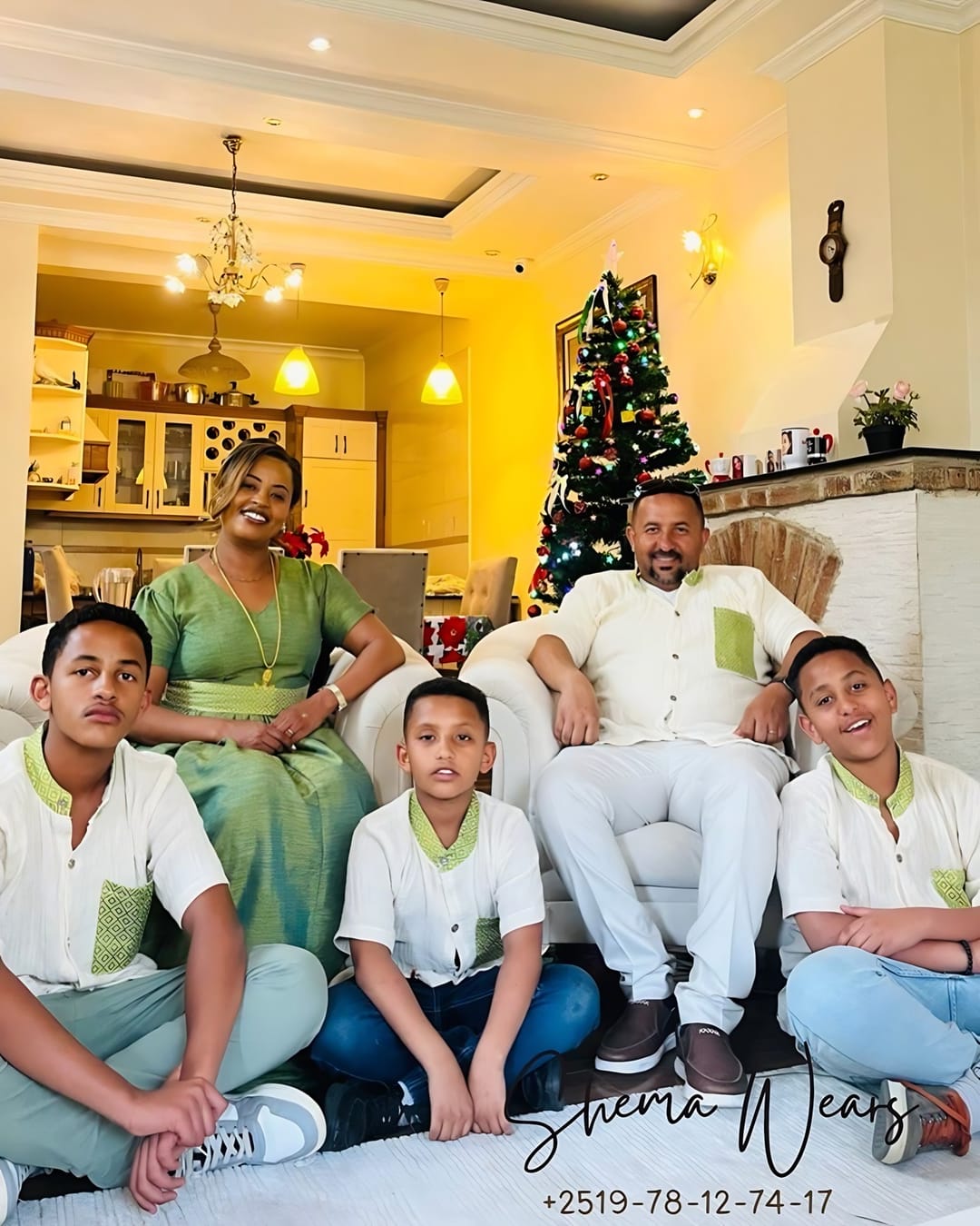A family in matching sage green and white — the mother in a green dress, the father and sons in white shirts with green detail