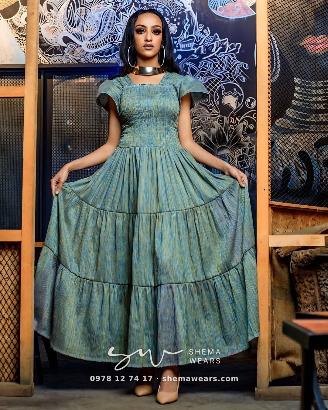 Model in a long sage green tiered dress with a smocked bodice and ruffled cap sleeves